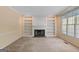Inviting living room featuring a fireplace, built-in bookshelves, and natural light from a nearby window at 9276 Fieldstone Ct, Jonesboro, GA 30236