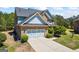 Side view of a two-story home showcasing brick and blue accents with an attached two-car garage at 1154 Ridge Hollow Ln, Lawrenceville, GA 30043