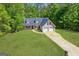 Aerial view of a charming home featuring a two-car garage, surrounded by a well-maintained yard with lush greenery at 1012 Miss Amber Way, Locust Grove, GA 30248