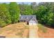 Aerial view of a charming two-story home surrounded by lush greenery, long driveway, and a two-car garage at 1012 Miss Amber Way, Locust Grove, GA 30248