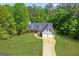 Aerial view of a charming home with a two-car garage and a well-maintained yard surrounded by lush greenery at 1012 Miss Amber Way, Locust Grove, GA 30248