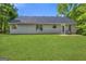 View of back exterior with expansive green lawn and grey siding at 1012 Miss Amber Way, Locust Grove, GA 30248