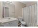 A tidy bathroom with single vanity, a large mirror, and a shower/tub with a striped curtain at 1012 Miss Amber Way, Locust Grove, GA 30248