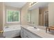 Bright bathroom with a large soaking tub under a sunlit window at 1012 Miss Amber Way, Locust Grove, GA 30248