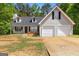 Charming two-story home with a two-car garage, dormer windows, and a cozy front porch with rocking chairs at 1012 Miss Amber Way, Locust Grove, GA 30248