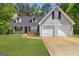Charming two-story home with a well-manicured lawn, two car garage, and inviting front porch with rocking chairs at 1012 Miss Amber Way, Locust Grove, GA 30248