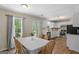 Eat-in kitchen with white cabinets, modern appliances, view to back yard and table with seating for six at 1012 Miss Amber Way, Locust Grove, GA 30248