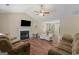 Inviting living room with vaulted ceiling, fireplace, ceiling fan, and an open view into the adjacent dining area at 1012 Miss Amber Way, Locust Grove, GA 30248