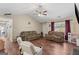 Spacious living room with a ceiling fan, wood-look flooring, and plush seating for the whole Gathering to enjoy at 1012 Miss Amber Way, Locust Grove, GA 30248