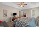 The main bedroom showcases the bed, ceiling fan, a dresser with a TV, and gray futon at 1012 Miss Amber Way, Locust Grove, GA 30248