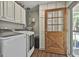 Spacious laundry room with wooden door, washer, and dryer at 160 Wills Way, Fayetteville, GA 30214
