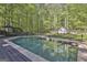 Inviting swimming pool surrounded by lush greenery and an umbrella-covered patio at 160 Wills Way, Fayetteville, GA 30214
