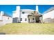 Large, green backyard with a covered stone patio and white exterior at 44 Mediterranean Ave, Sharpsburg, GA 30277