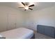 Bright bedroom with ceiling fan, carpet flooring, a gray dresser and two closets at 44 Mediterranean Ave, Sharpsburg, GA 30277