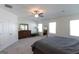 Comfortable bedroom features carpet flooring, a ceiling fan, and a large dresser at 44 Mediterranean Ave, Sharpsburg, GA 30277