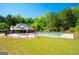Fenced community pool with a covered seating area surrounded by lush green trees at 44 Mediterranean Ave, Sharpsburg, GA 30277