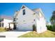 Two car garage of a charming two-story white home and lush green lawn at 44 Mediterranean Ave, Sharpsburg, GA 30277