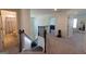 Upstairs landing with dark metal railing and carpet flooring and multiple doors to different rooms at 44 Mediterranean Ave, Sharpsburg, GA 30277