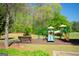A colorful playground with slides, a bench, and lush green trees creating a fun community space at 44 Mediterranean Ave, Sharpsburg, GA 30277