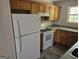 Functional kitchen featuring wood cabinets, a white refrigerator, and standard white appliances at 2039 Faith Cv, College Park, GA 30349