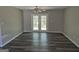 This living room boasts laminate floors, neutral paint, a ceiling fan, and French doors to the backyard at 2039 Faith Cv, College Park, GA 30349