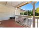 Covered back porch with seating, railing, and view of the landscaped backyard at 2354 Hamilton St, Hampton, GA 30228