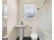 Simple bathroom featuring white fixtures, tiled shower, and a window for natural light at 2354 Hamilton St, Hampton, GA 30228