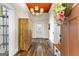Foyer with a beautiful light fixture, wood floors, and a vibrant floral wreath on the door at 2354 Hamilton St, Hampton, GA 30228