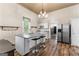 Bright, open kitchen has a granite island, seating, and stainless steel refrigerator at 2354 Hamilton St, Hampton, GA 30228