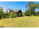 Rustic outbuilding with metal roof surrounded by greenery in spacious backyard at 2354 Hamilton St, Hampton, GA 30228