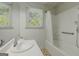 Bathroom with a single sink, tub shower, handrails, and natural light at 395 Hood Ave, Fayetteville, GA 30214