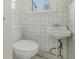 Small bathroom featuring a white tiled wall, toilet and corner sink with chrome faucet at 395 Hood Ave, Fayetteville, GA 30214