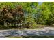 Street view featuring a home surrounded by mature trees and landscaping at 395 Hood Ave, Fayetteville, GA 30214