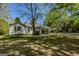 Single-story home with carport and lush front lawn and landscaping beneath a clear blue sky at 395 Hood Ave, Fayetteville, GA 30214