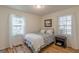 Bright bedroom featuring hardwood floors, two windows and a comfortable patterned bed at 1325 E Forrest Ave, East Point, GA 30344