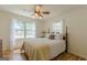 Bright bedroom features a wooden bed frame, ceiling fan, and abundant natural light from two windows at 1325 E Forrest Ave, East Point, GA 30344