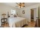 Cozy bedroom with hardwood floors, a four poster bed, and ample lighting from ceiling fan and windows at 1325 E Forrest Ave, East Point, GA 30344