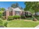 Charming brick home featuring a well-maintained lawn, mature trees, and classic black shutters at 1325 E Forrest Ave, East Point, GA 30344