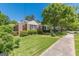 Charming brick home featuring a well-maintained lawn, mature trees, and classic black shutters at 1325 E Forrest Ave, East Point, GA 30344