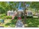 Charming brick home featuring a well-maintained lawn, mature trees, and classic black shutters at 1325 E Forrest Ave, East Point, GA 30344