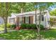 Charming brick home featuring a well-maintained lawn, mature trees, and classic black shutters at 1325 E Forrest Ave, East Point, GA 30344