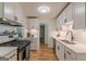 Modern kitchen features white cabinets, stainless steel appliances, and beautiful hardwood flooring at 1325 E Forrest Ave, East Point, GA 30344