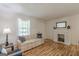 Bright living room featuring hardwood floors, a cozy fireplace, and comfortable seating at 1325 E Forrest Ave, East Point, GA 30344