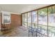Screened porch with wooden floors, outdoor dining set, and brick accent wall at 1325 E Forrest Ave, East Point, GA 30344