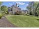 Exterior view of a home with a large, grassy backyard, deck and patio with stairs leading to the backyard at 1105 Astoria Ln, Peachtree City, GA 30269