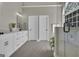Modern bathroom with double vanity, white cabinets, and large glass shower with an arched window at 1105 Astoria Ln, Peachtree City, GA 30269