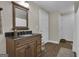 Bathroom with wood vanity, granite top, framed mirror, decorative lighting, wood flooring and neutral paint at 1105 Astoria Ln, Peachtree City, GA 30269