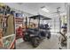 Garage interior showcasing a dark blue golf cart, storage shelving and concrete wall and floor at 1105 Astoria Ln, Peachtree City, GA 30269