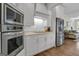 Well-lit kitchen with stainless steel appliances, white cabinets, and hardwood flooring at 1105 Astoria Ln, Peachtree City, GA 30269