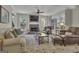 Bright living room featuring a stone fireplace with TV, comfortable seating, and ample natural light from large windows at 1105 Astoria Ln, Peachtree City, GA 30269